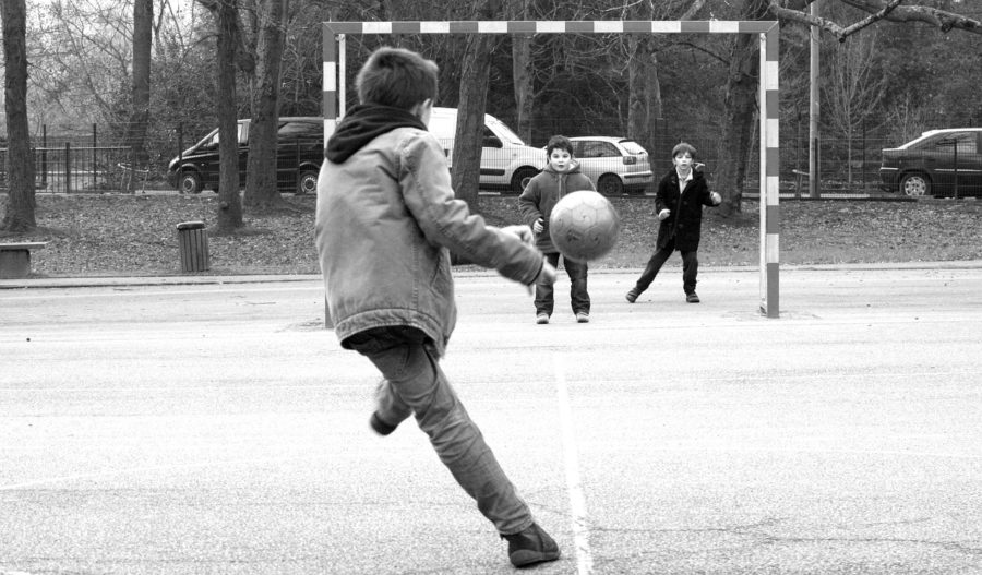公園でサッカーをする子どもたちの写真